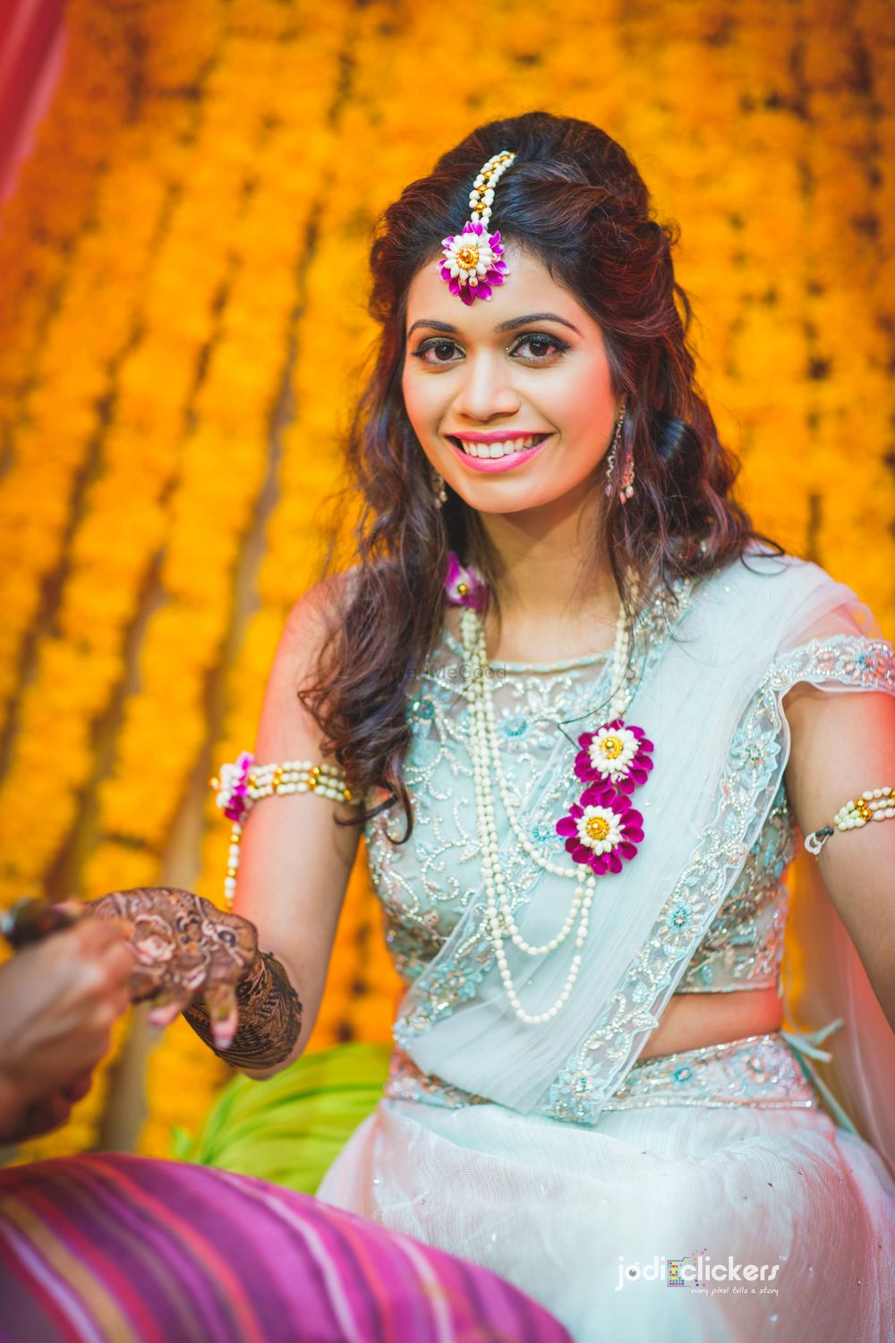 Photo of Bride wearing light blue mehendi and floral jewellery