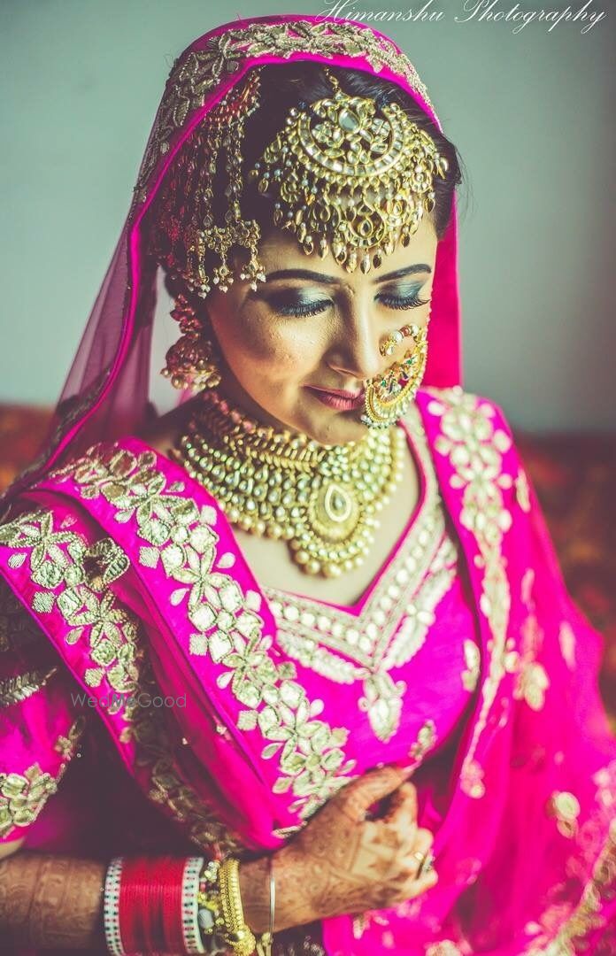 Photo of Bride wearing bold bridal jewellery with maangtikka and jhoomer