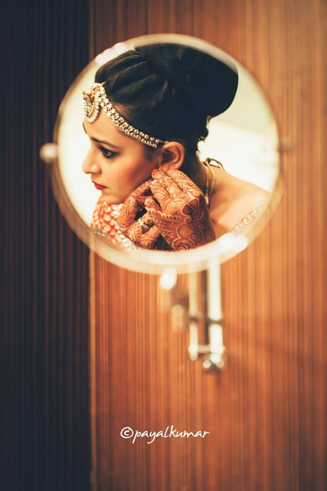 Photo of Bride reflection in mirror while getting ready