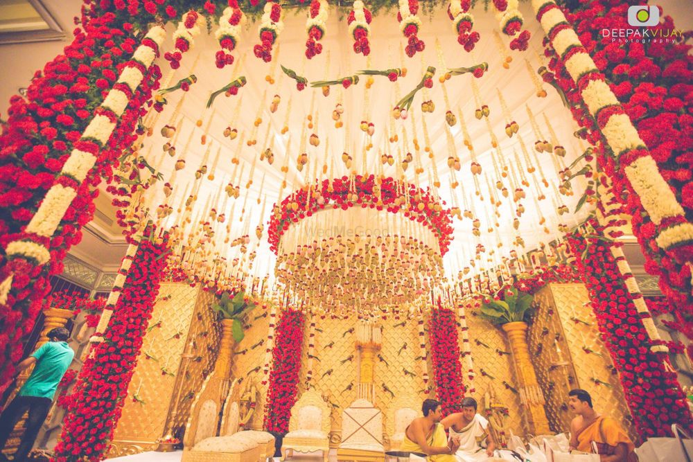 Photo of Elaborate red and white mandap with hanging floral strings