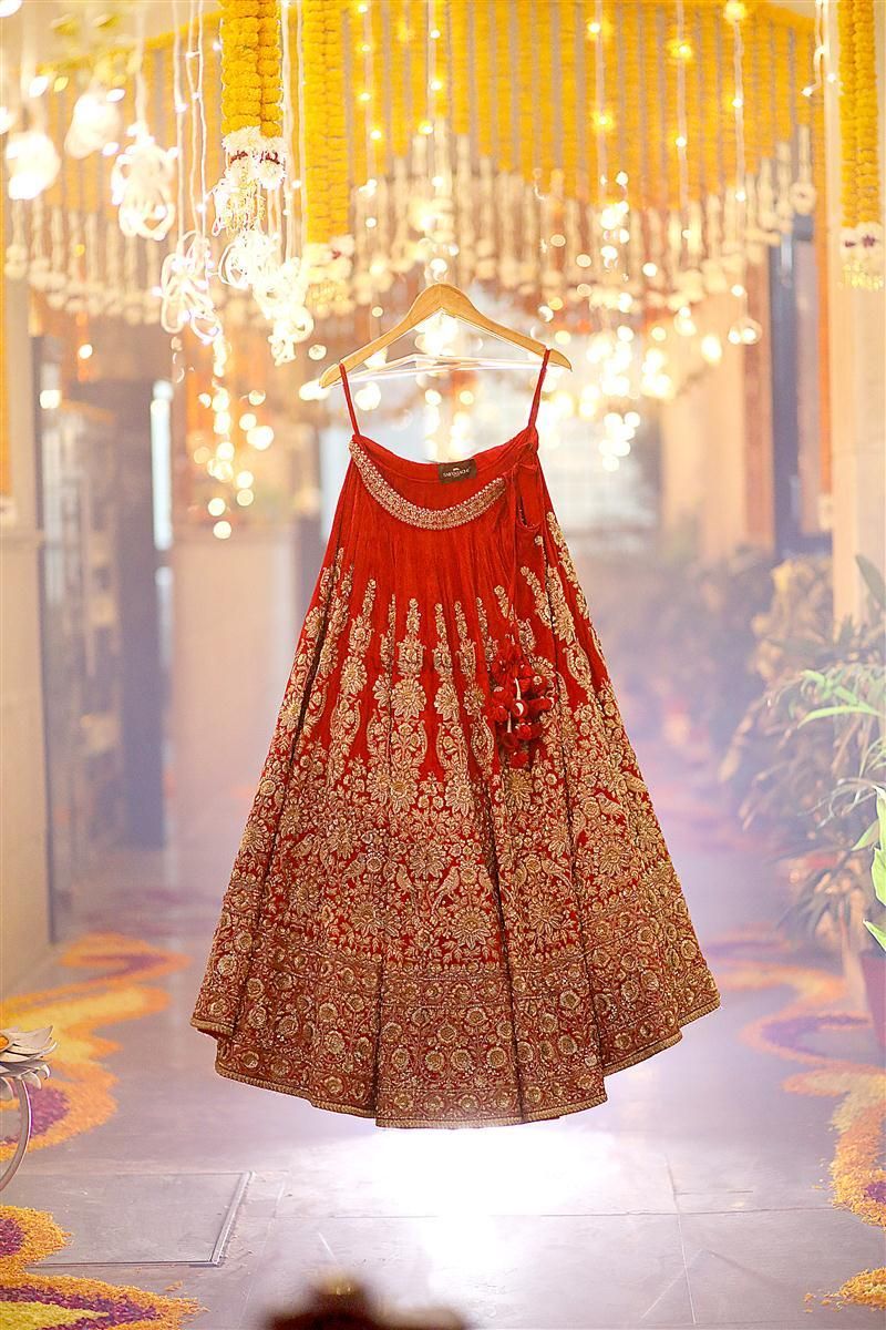 Photo of Red and gold bridal lehenga skirt on hanger