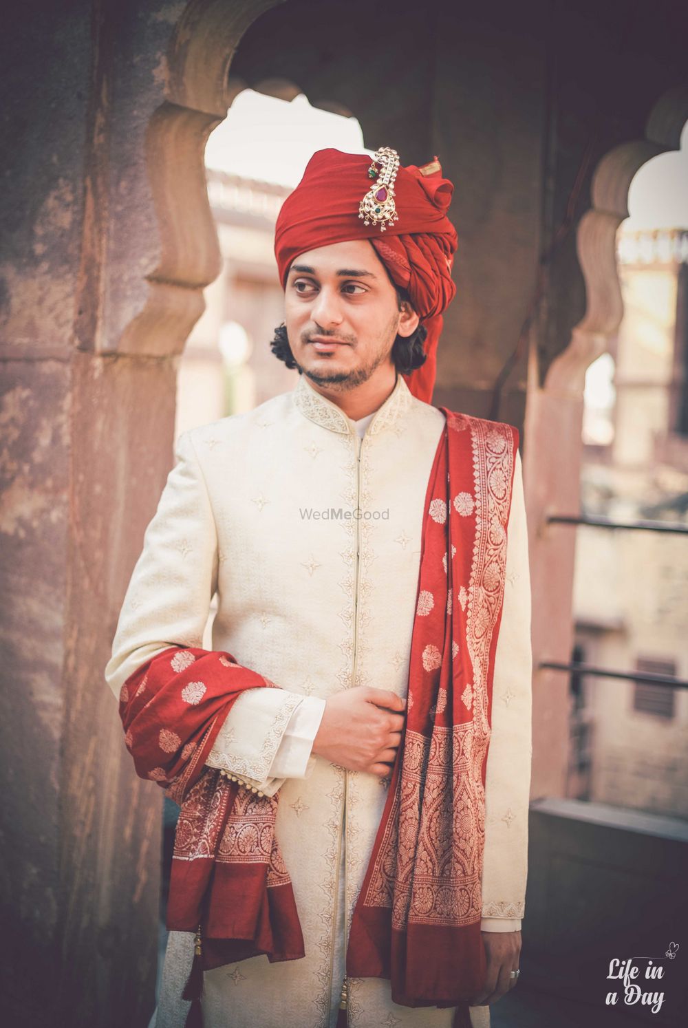 Photo of Off white sherwani with red safa and stole