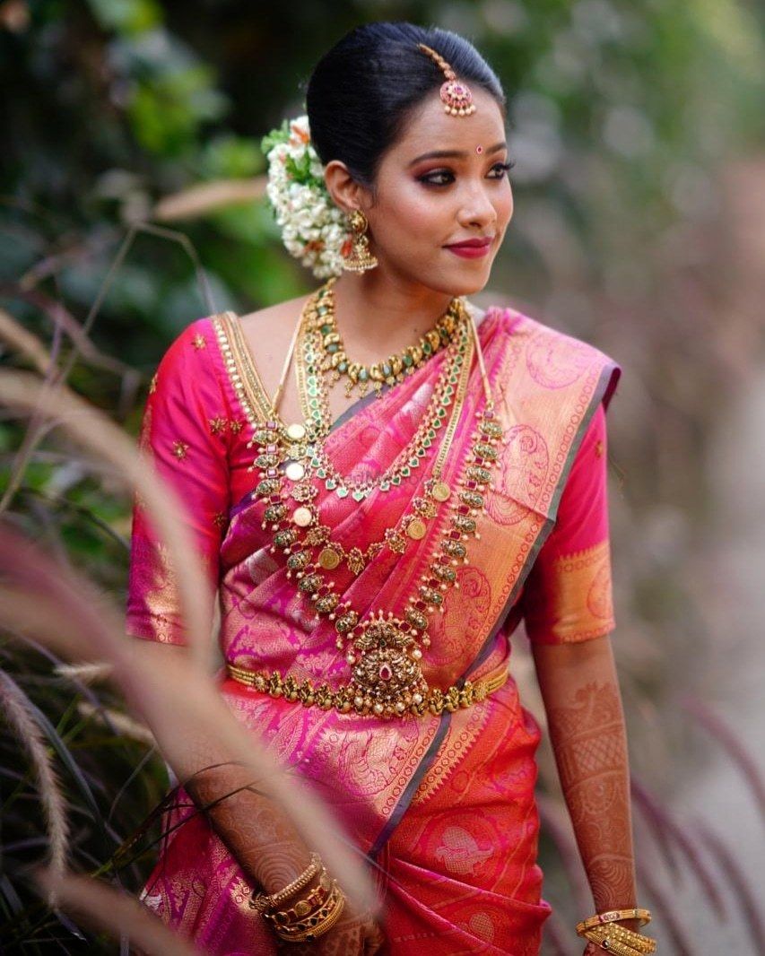 Photo of South Indian Bride wearing a pink silk saree with temple jewellery.