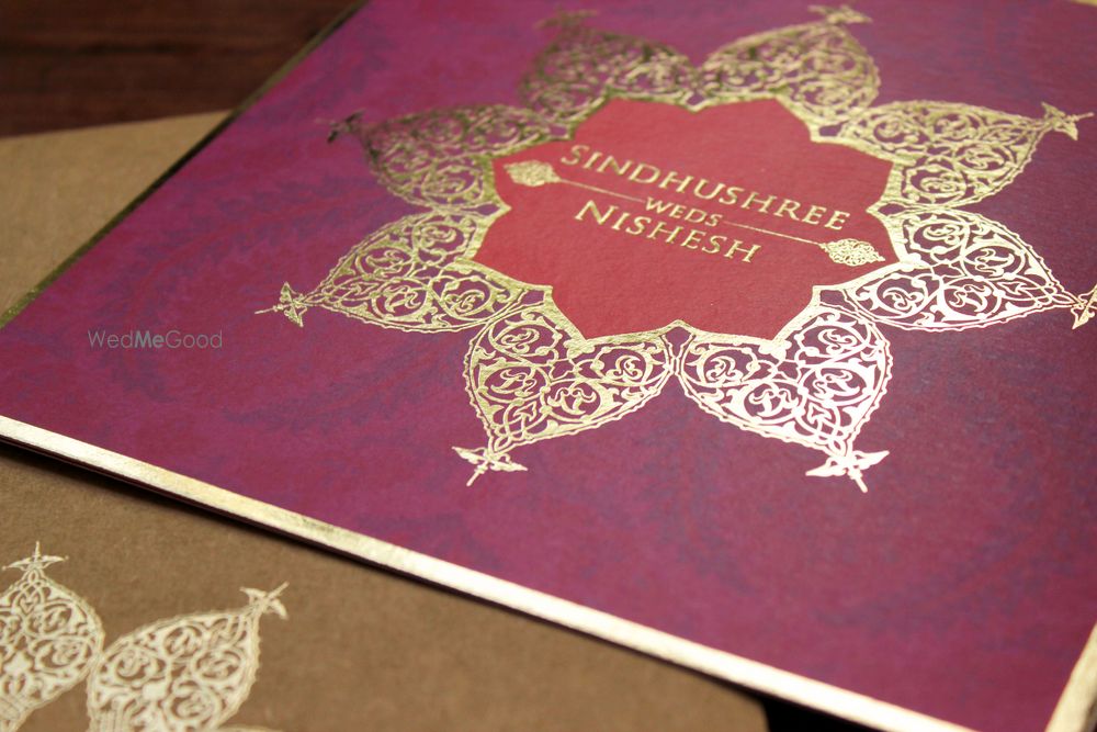 Photo of purple and gold wedding card