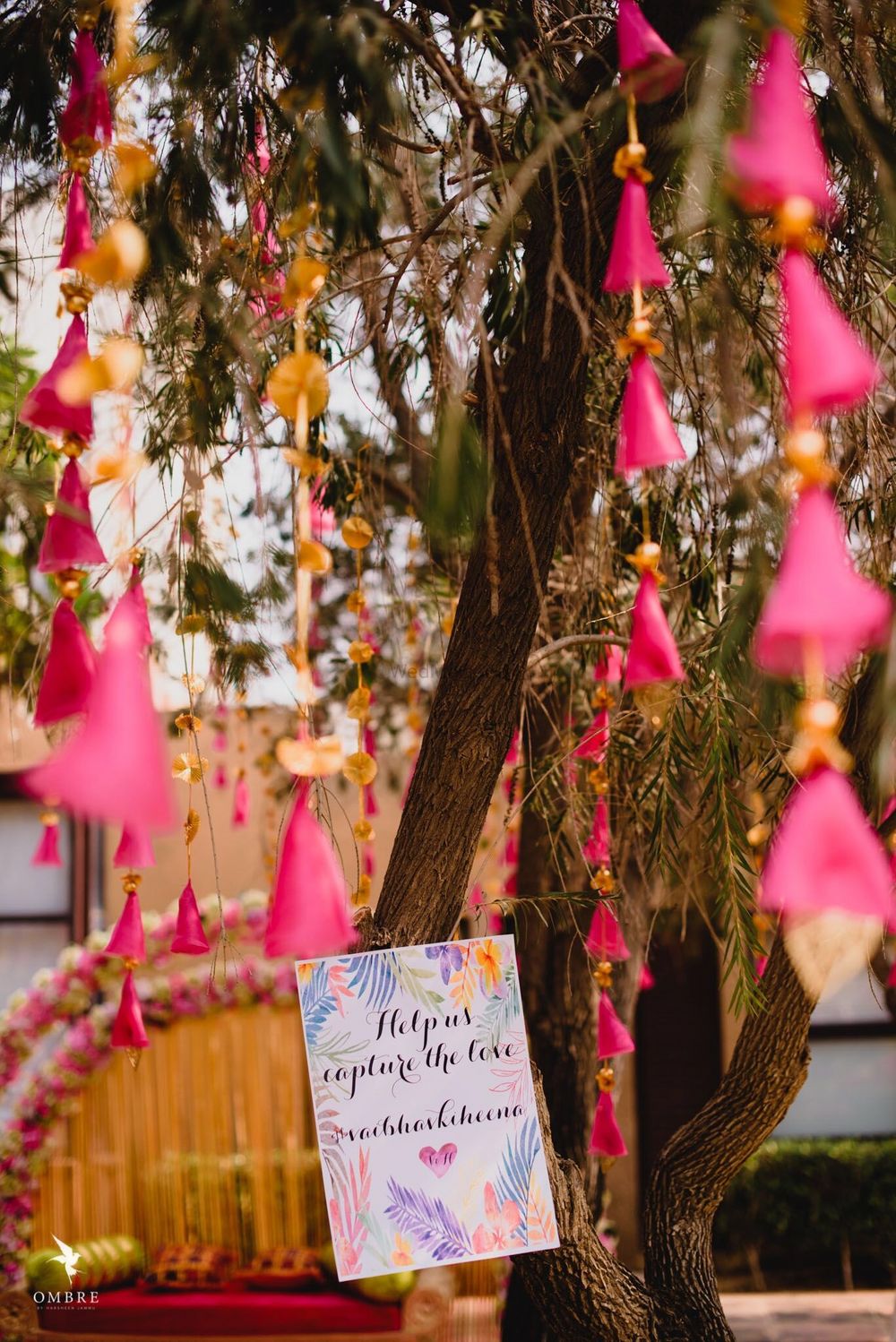 Photo of Mehendi decor with tassels and hashtag board