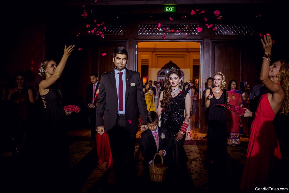 Photo of Guests throwing petals while couple enters
