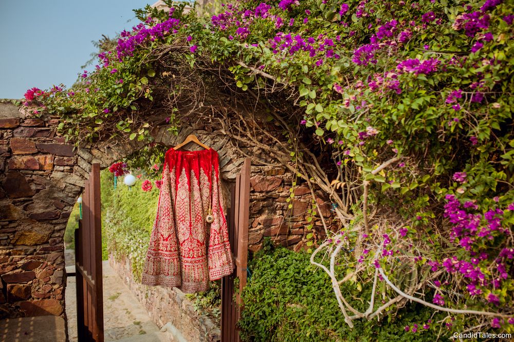 Photo of Red bridal lehenga on hanger outdoors