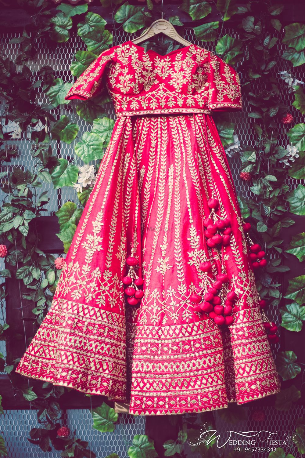 Photo of Red and gold bridal lehenga on hanger