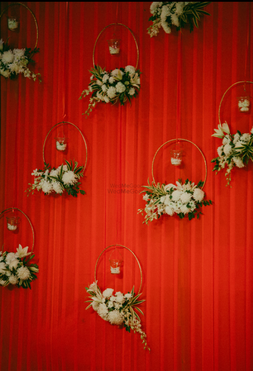 Photo of Red backdrop with floral wreaths and candles