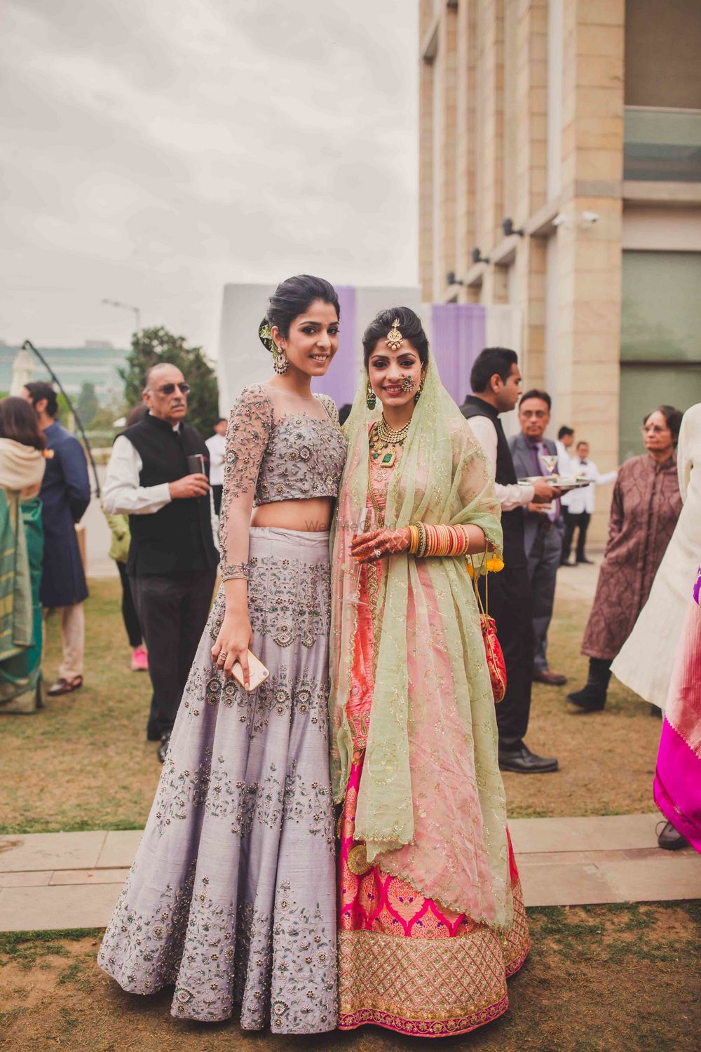 Photo of Bride with bridesmaid in dirty lilac lehenga