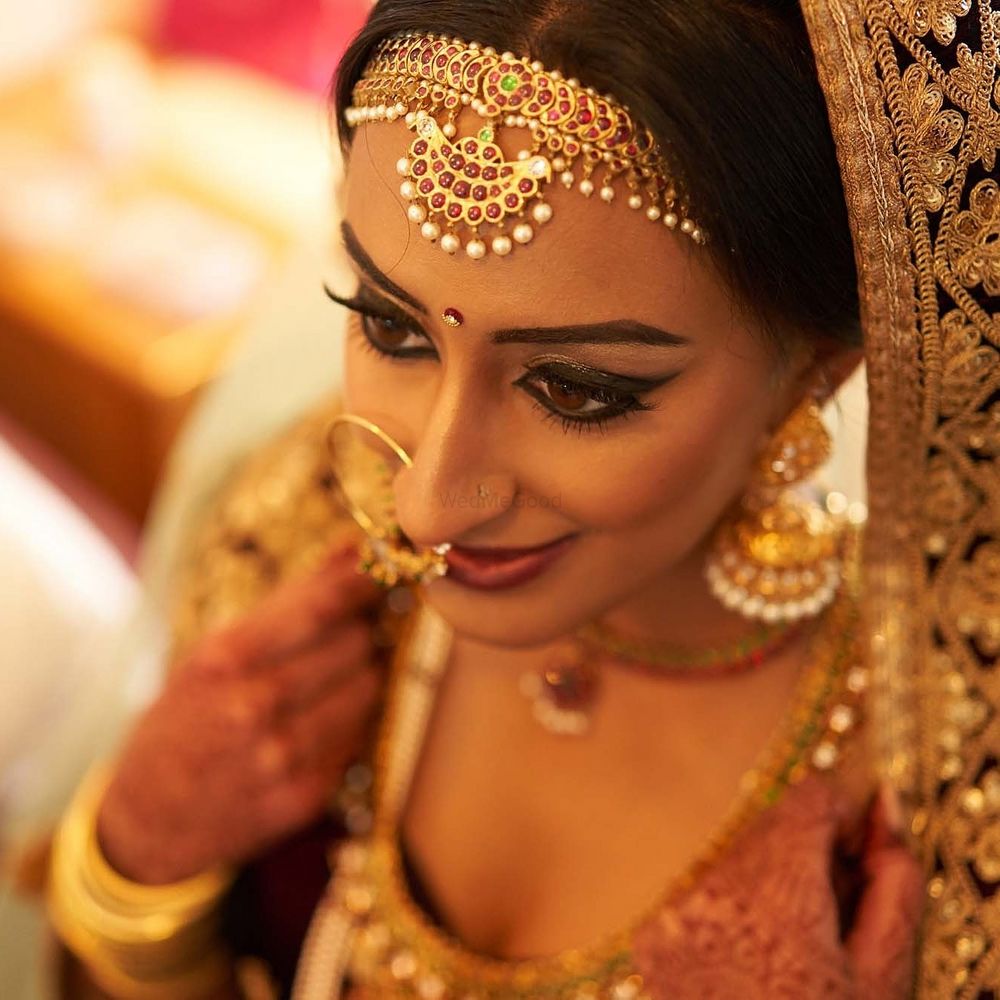 Photo of Bridal makeup with winged liner and unique mathapatti