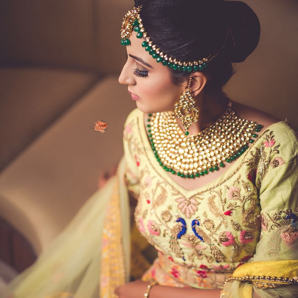 Photo of  bride in an offbeat yellow lehenga and heavy jewellery