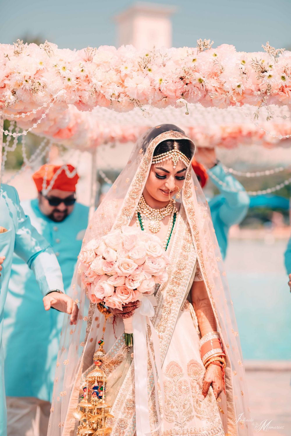 Photo of Beautiful bridal entry with peach lehenga and bouquet