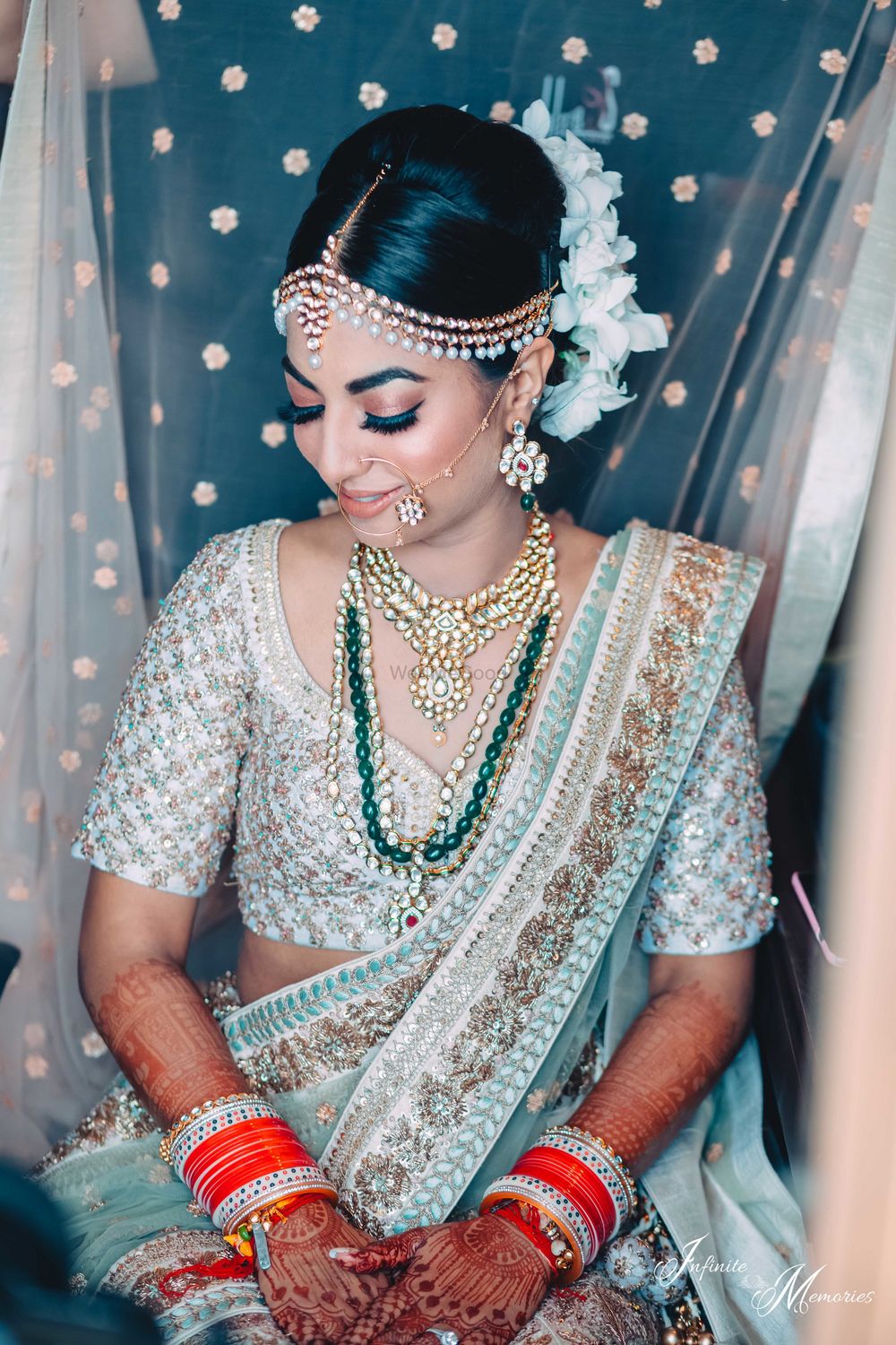 Photo of Offbeat bridal lehenga with dupatta placing on head shot