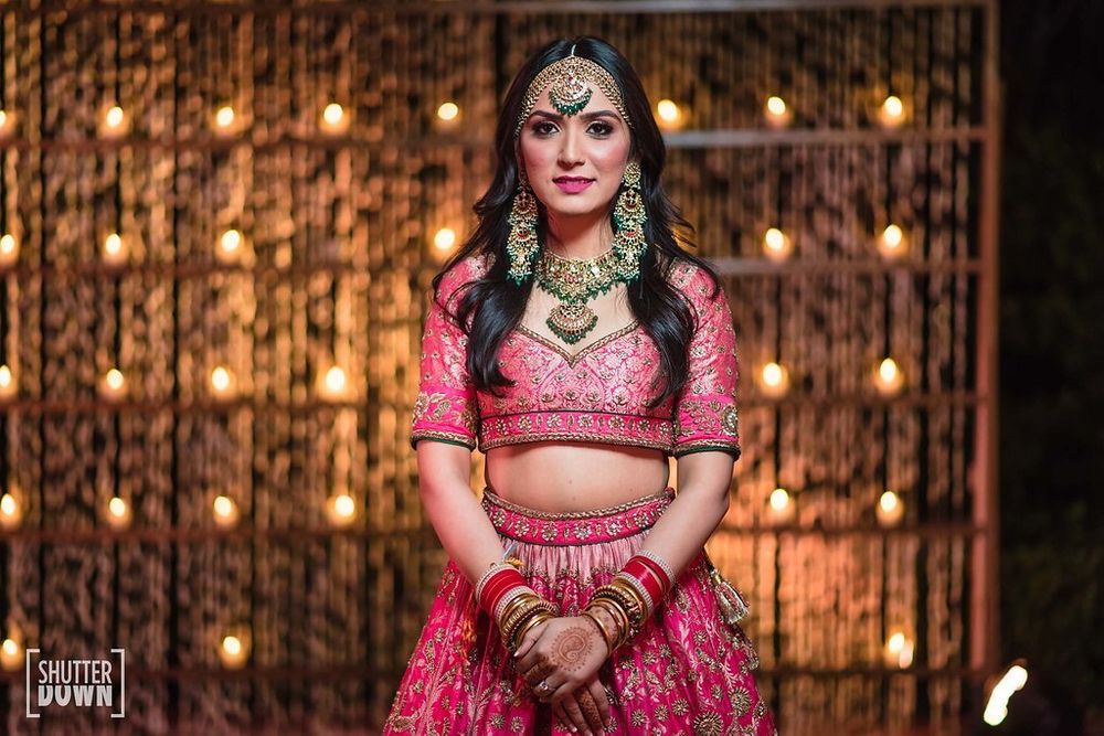 Photo of Bright pink lehenga with green jewellery and sweetheart neckline