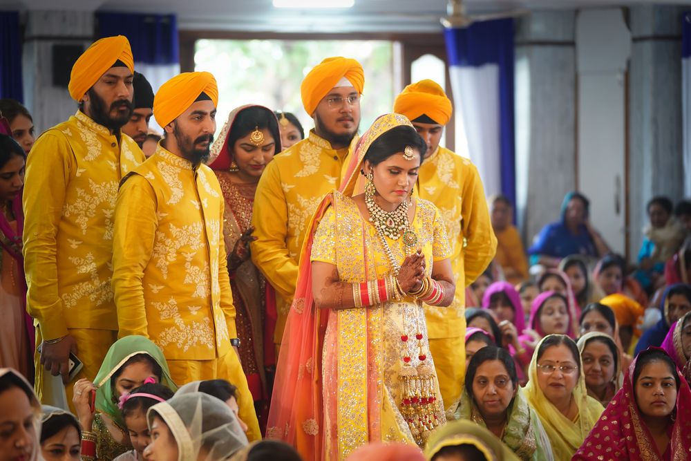 Photo of Brothers of the bride wore matching yellow floral jackets with the bride for her wedding day