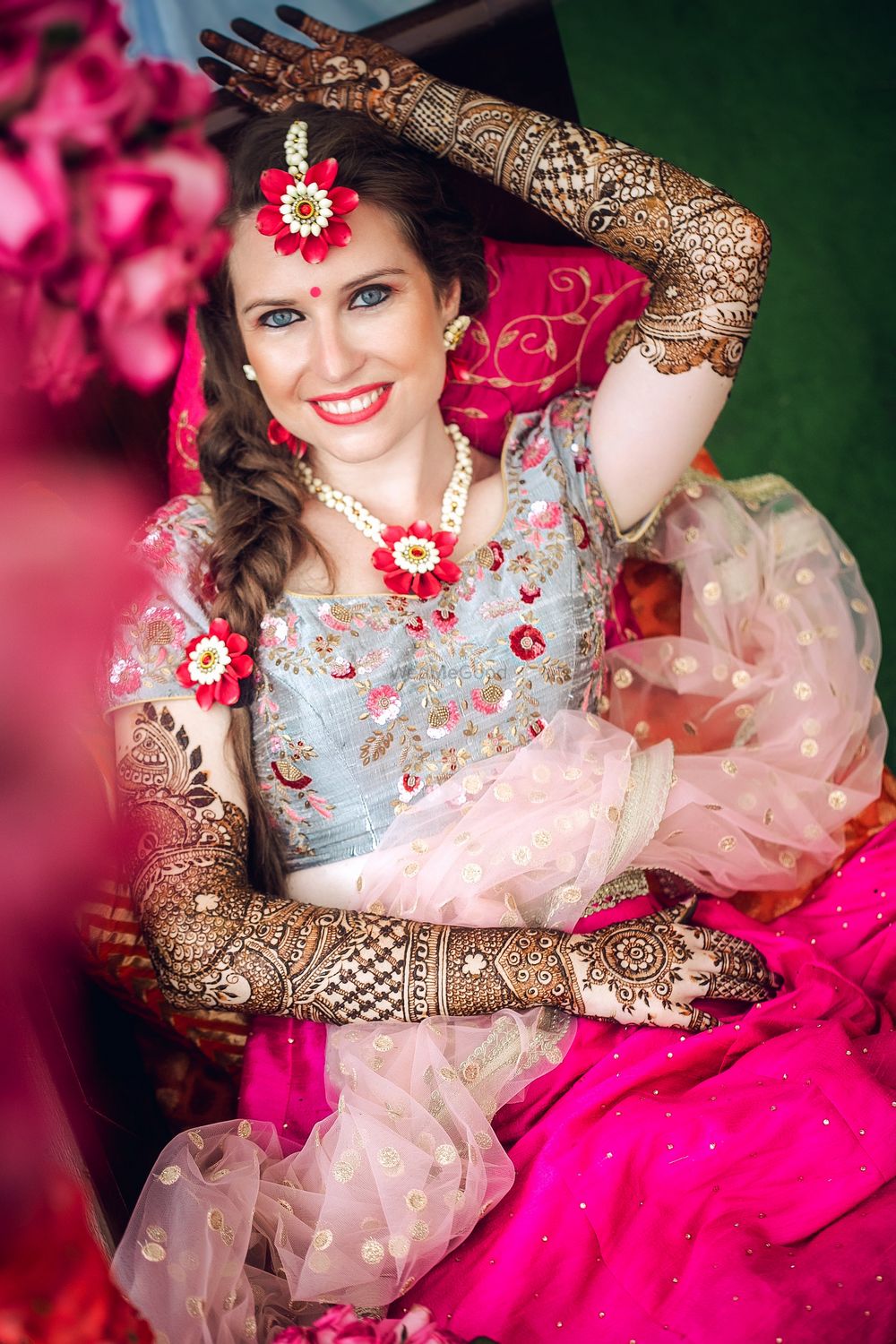 Photo of NRI bride in floral jewellery on mehendi