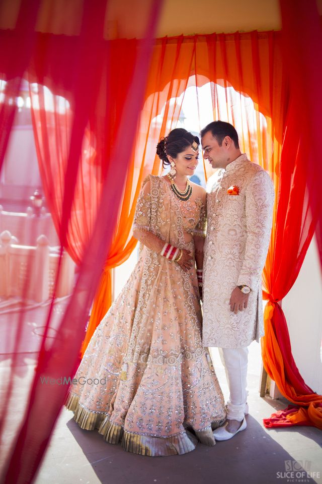 Photo of Bride and groom in matching cream outfits