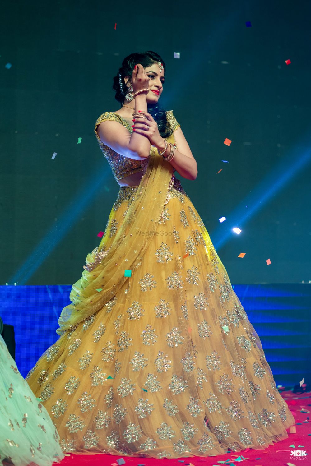 Photo of Bride dancing in yellow sangeet lehenga on stage