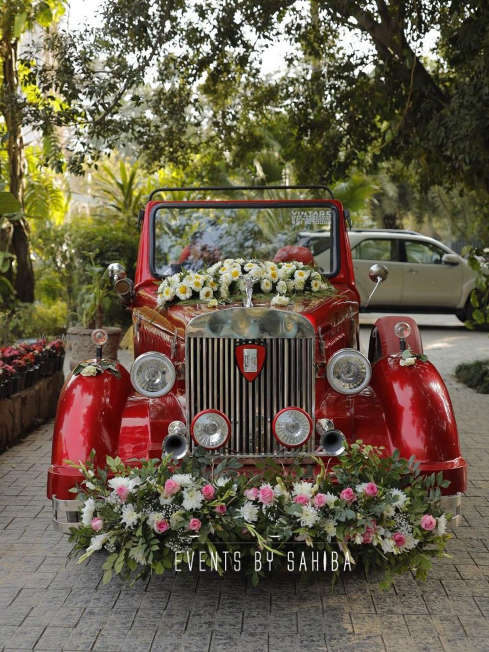 Photo of Super cute vintage car in red and floral arrangements