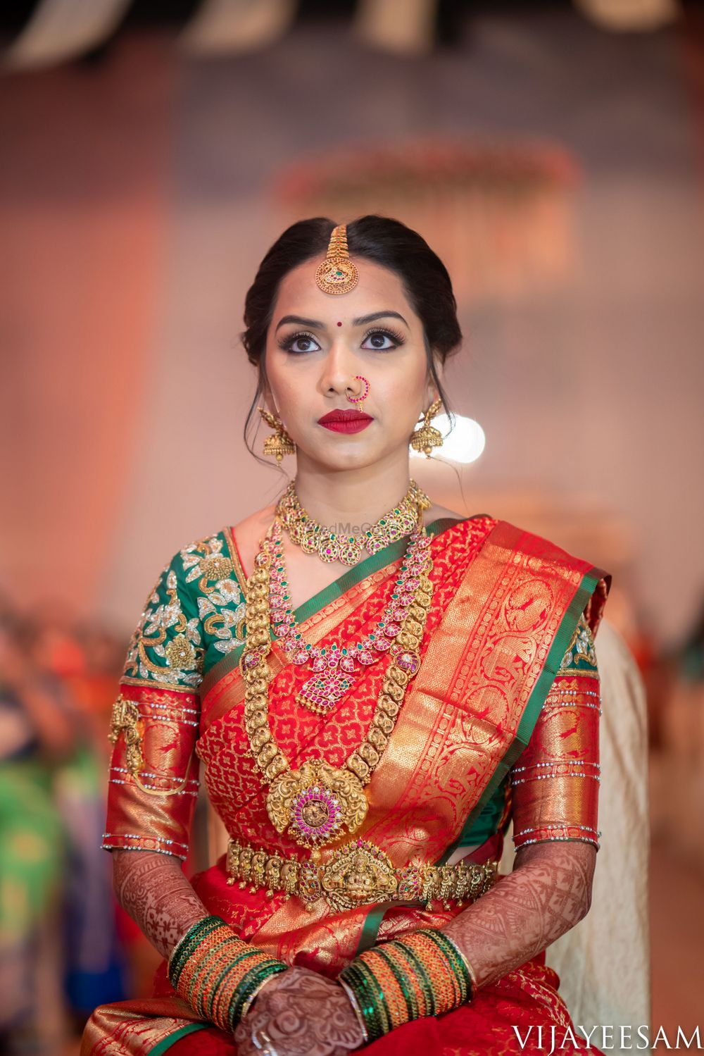 Photo of Bride in orange and green saree with layered temple jewellery