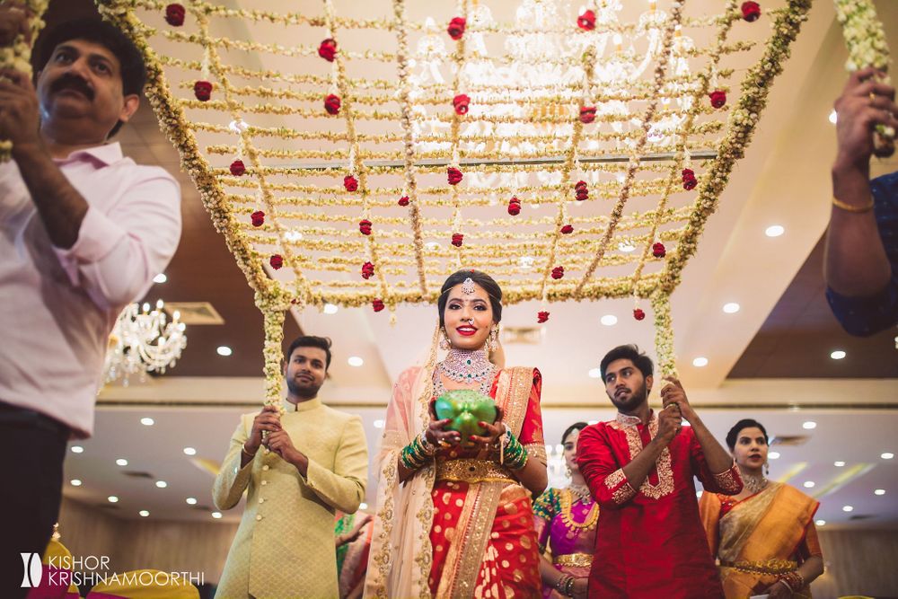 Photo of south indian fusion bridal entry under floral chadar