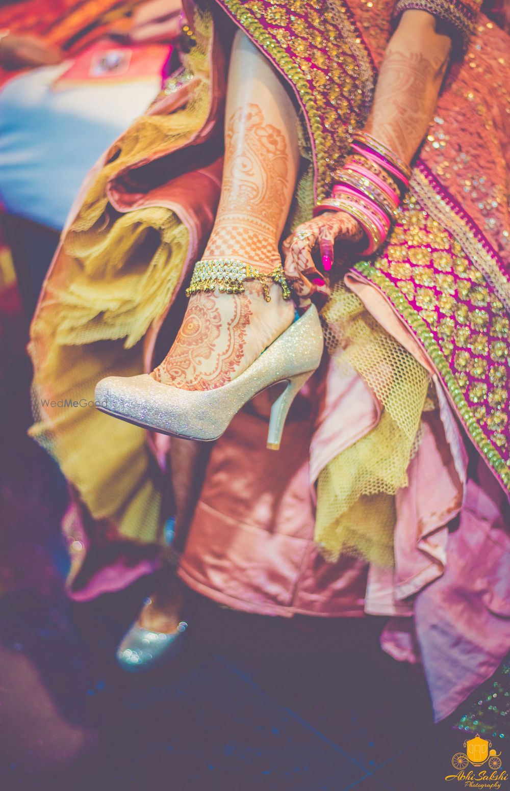 Photo of Bride getting ready shot putting on gold shoes