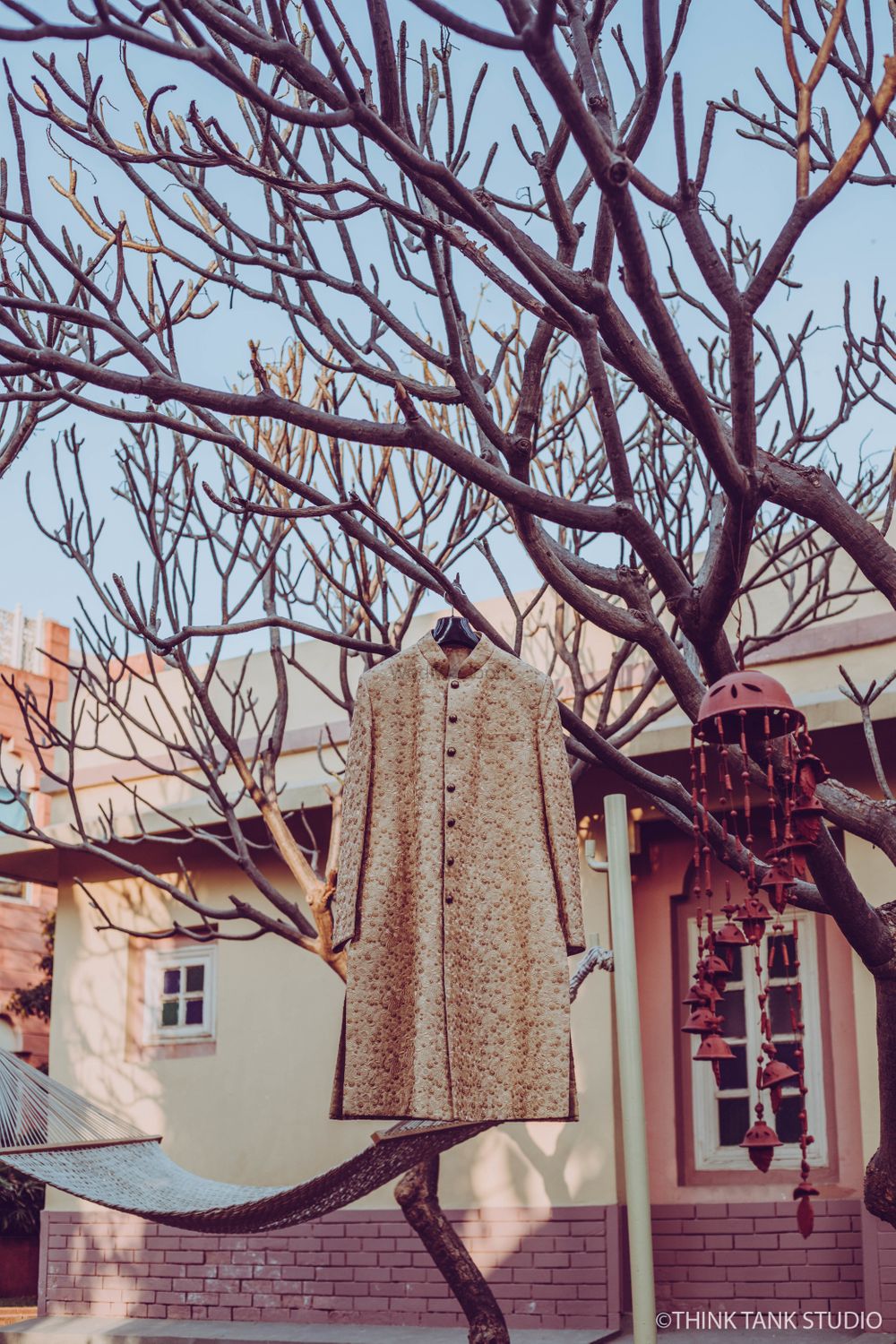 Photo of Cream sherwani hanging on tree