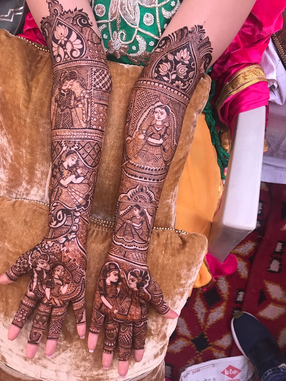 Photo of Gorgeous intricate mehendi with bride and groom caricatures.