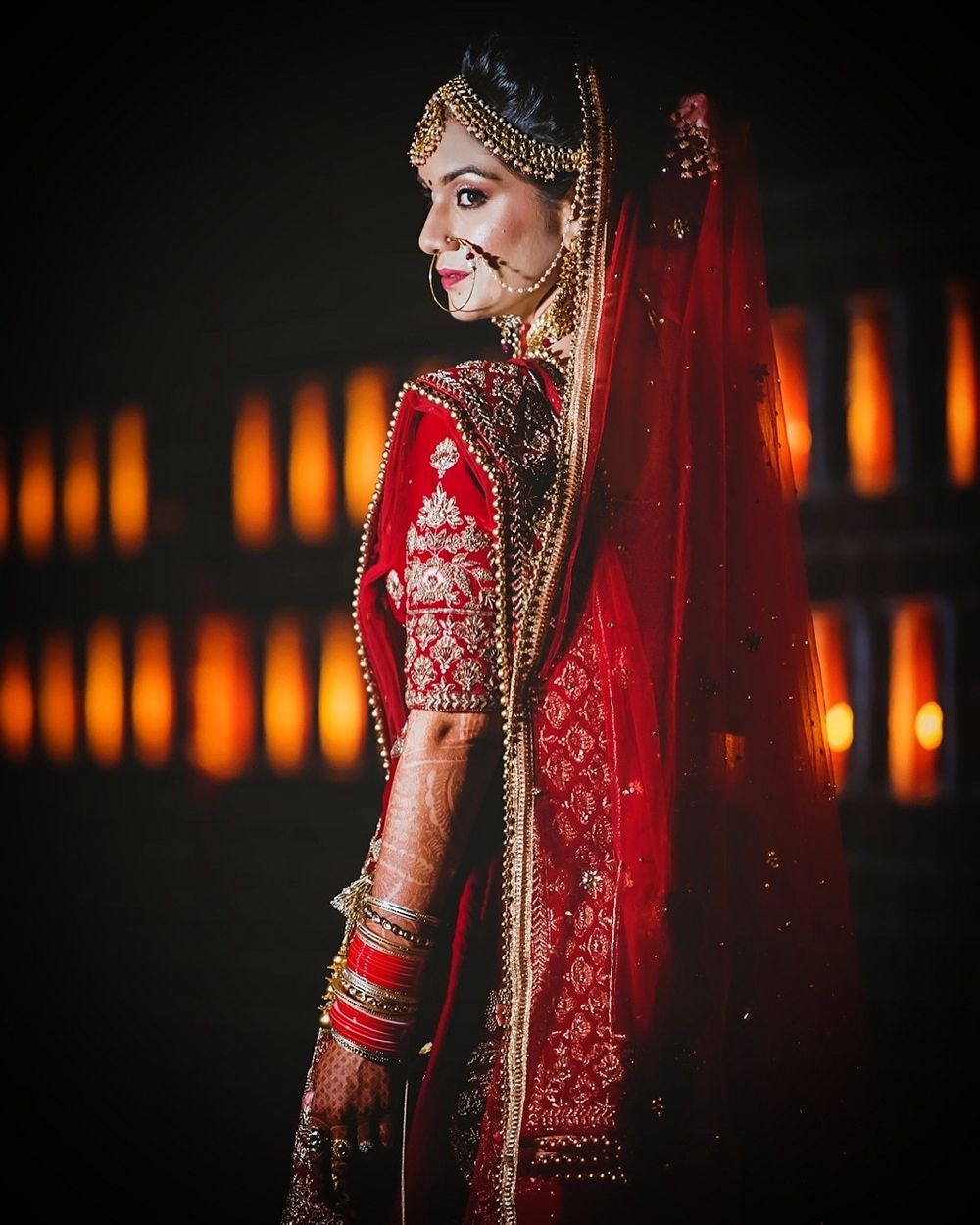 Photo of Bride in red lehenga posing for bridal portrait