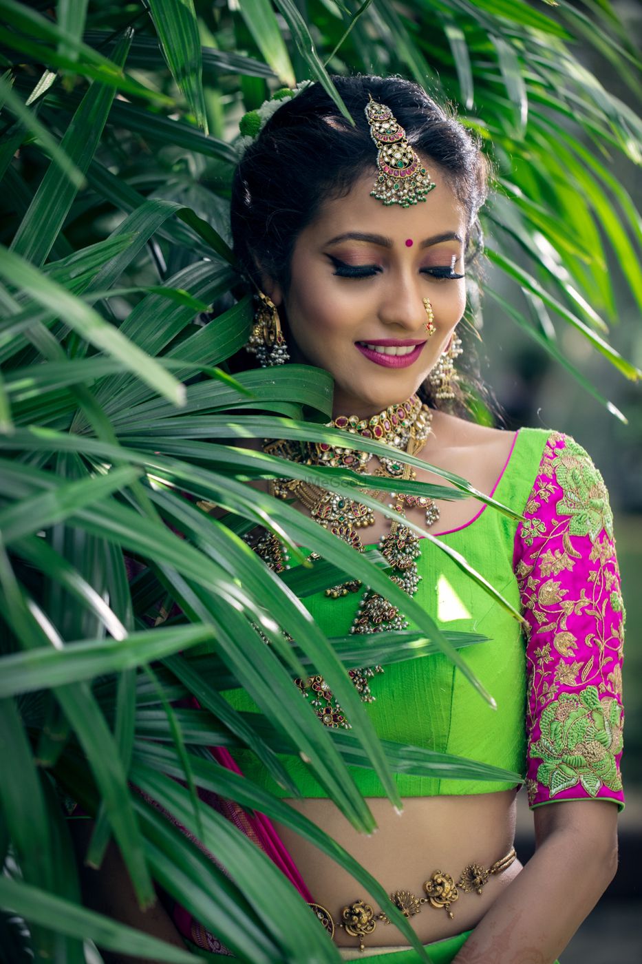 Photo of Bride in green and pink lehenga with embroidered sleeves