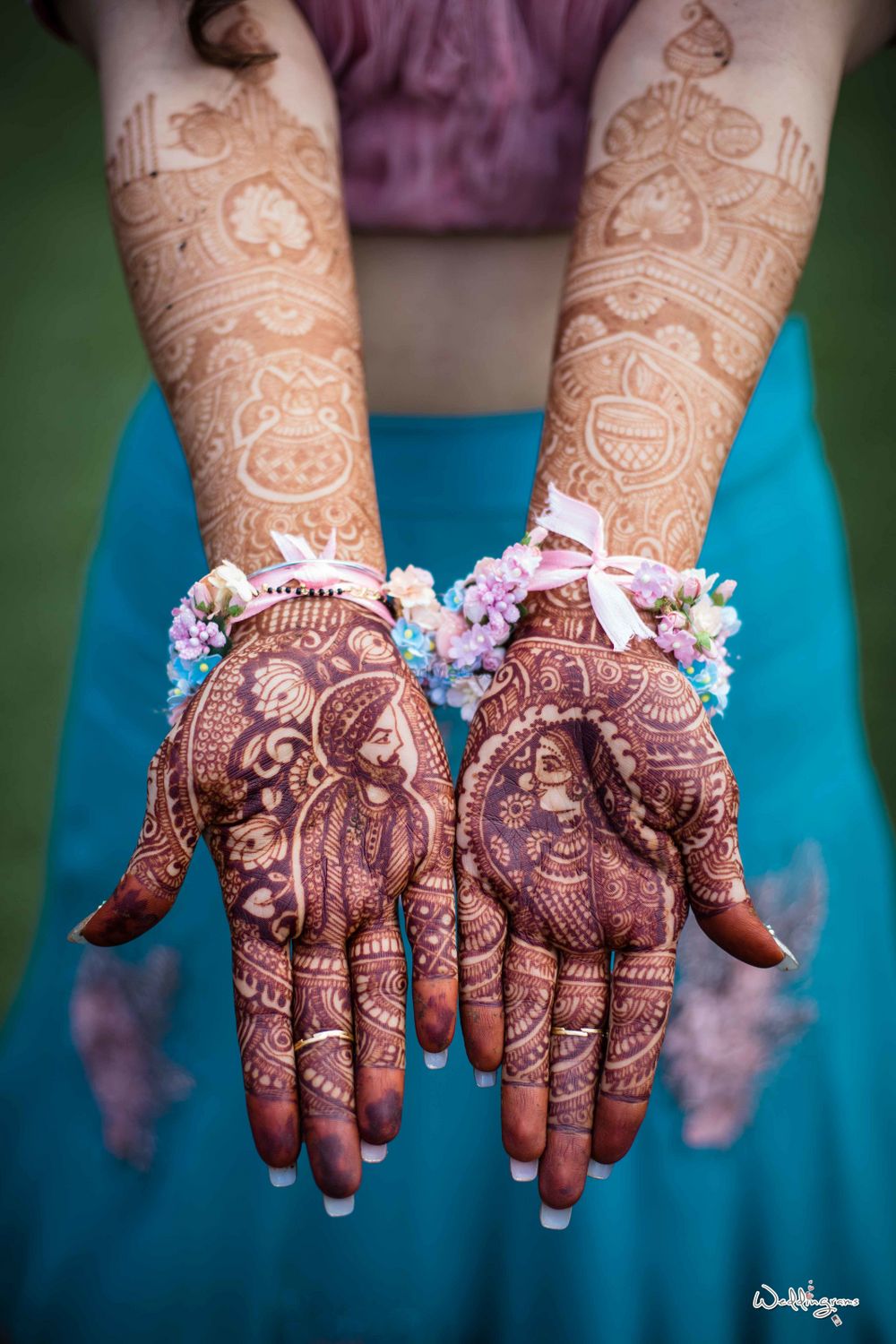 Photo of Bridal mehendi with bride and groom portraits made on it