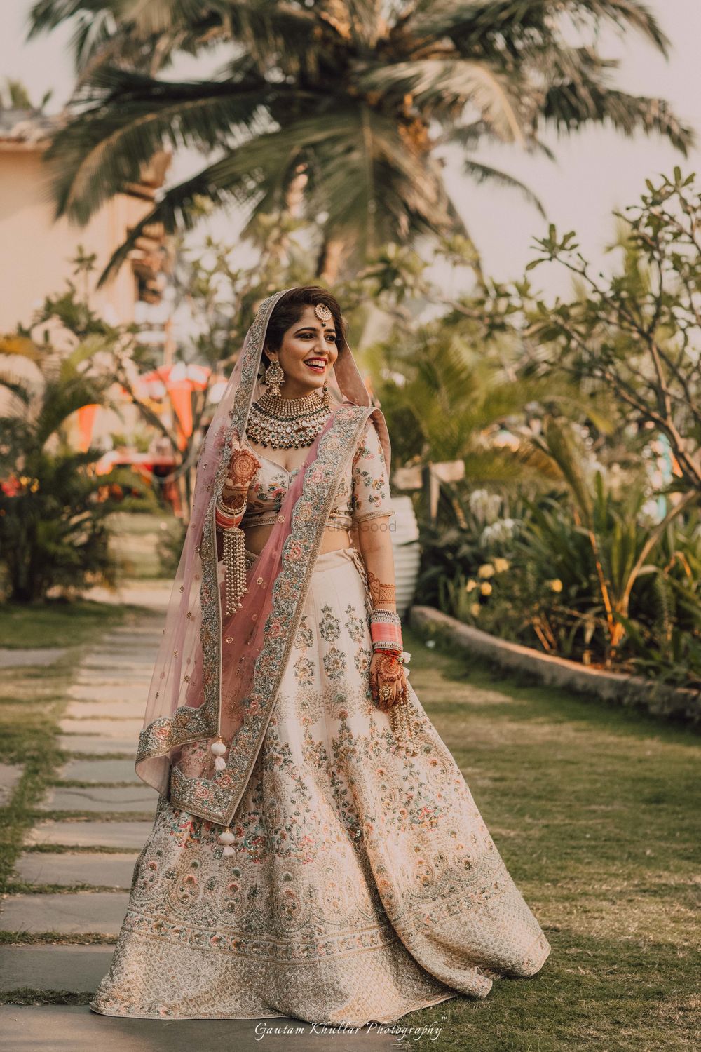 Photo of Bride in off white bridal lehenga with pink dupatta