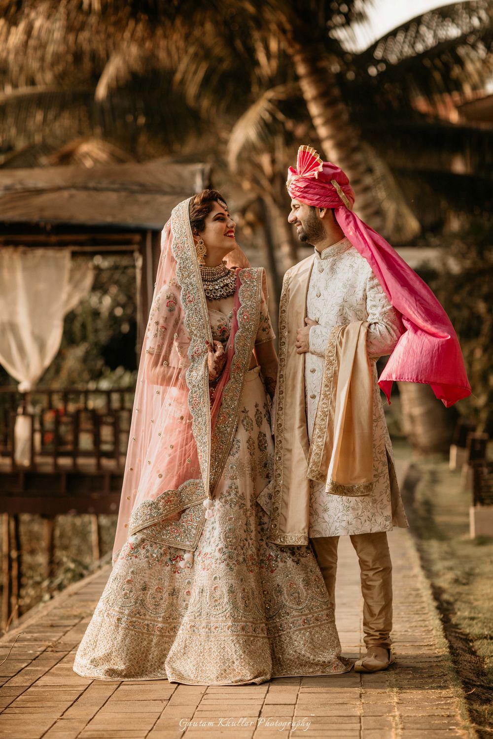 Photo of Coordinated matching bride and groom in pastel outfits with pink