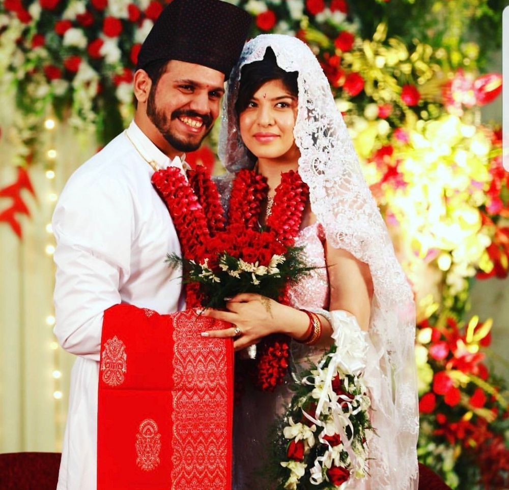 Photo of A parsi bride and groom in white and red