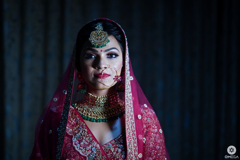 Photo of Contrasting jewellery with red lehenga bridal portrait