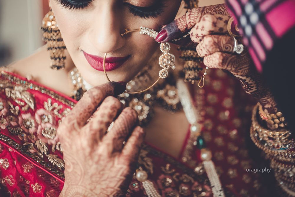 Photo of Bride putting on her Nath