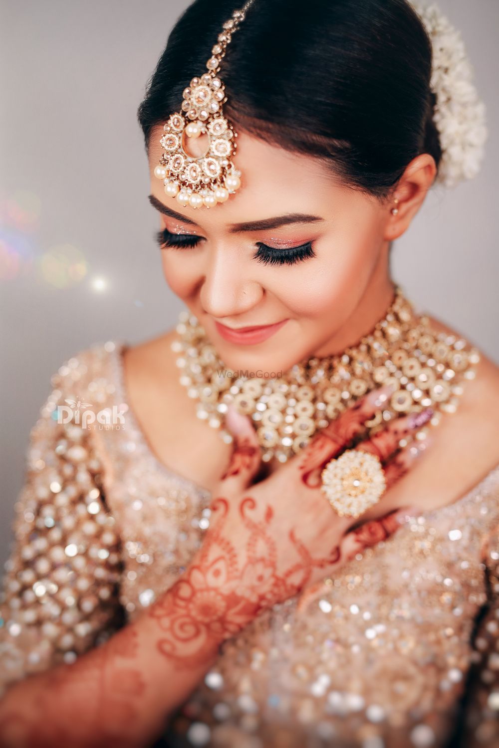 Photo of wedding day bridal portrait in gold lehenga and jewellery