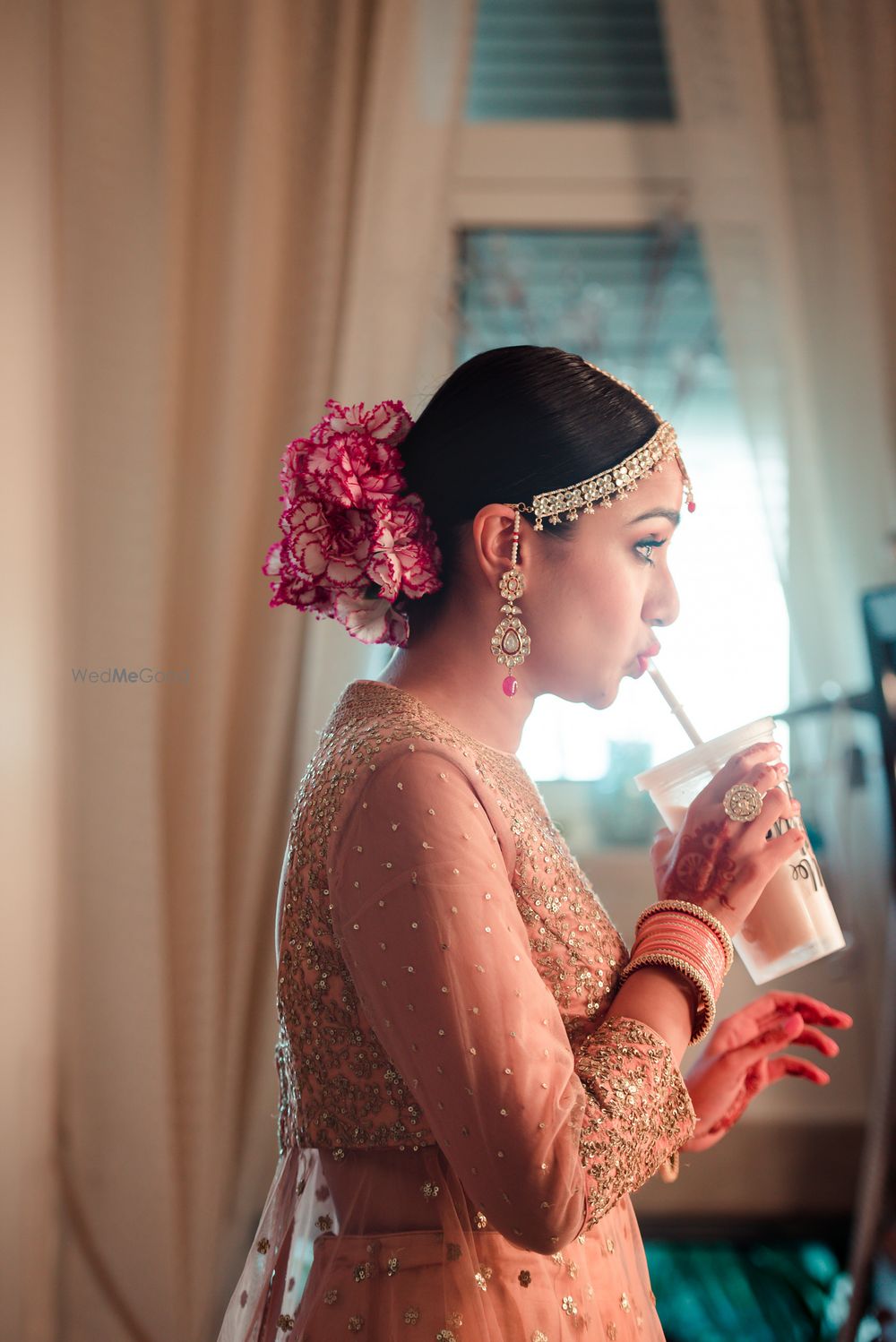 Photo of Unique bridal bun and bride sipping