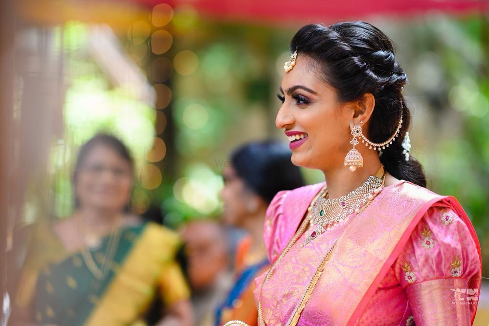 Photo of south indian bridal look in pink kanjivaram with twist hairdo