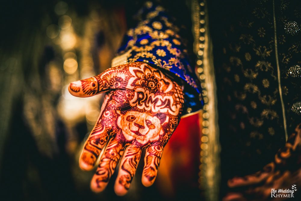 Photo of Groom wearing mehendi with brides name and a panda