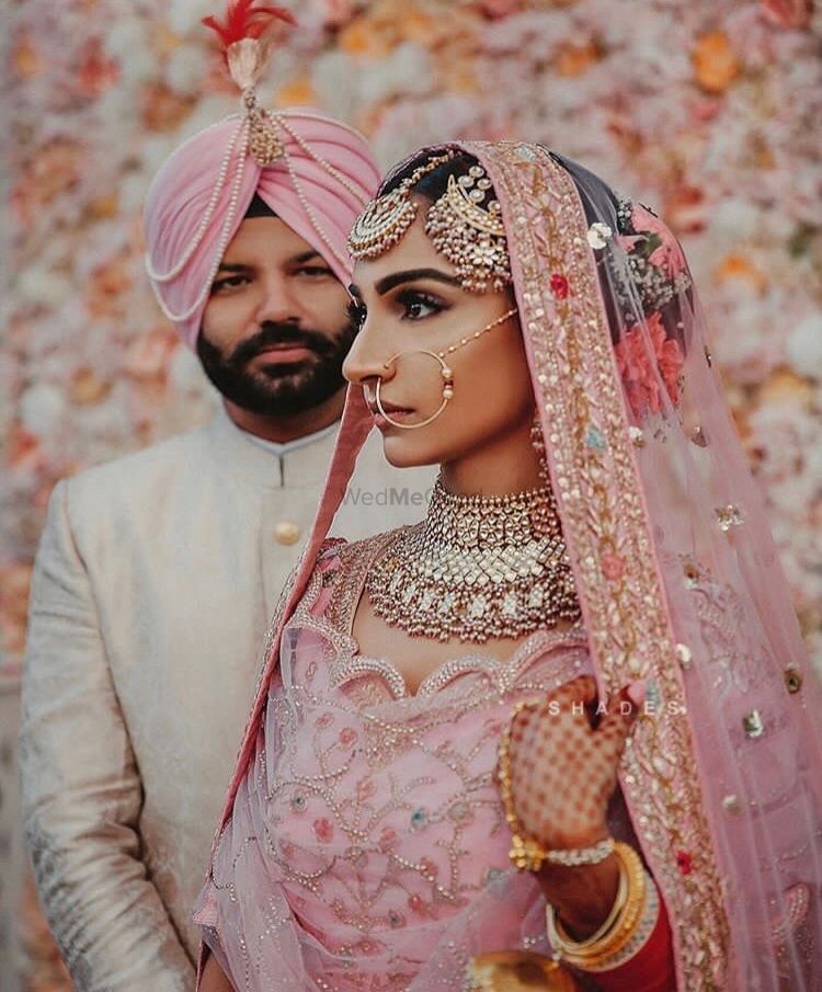 Photo of Couple portrait with bride in light pink lehenga and pretty jewellery