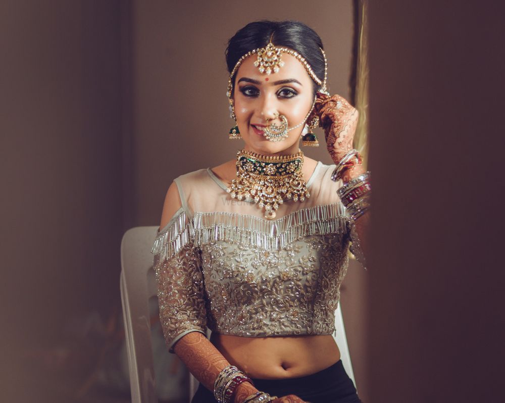 Photo of Indian bride wearing cold shoulder blouse with tassels with unique gold choker necklace