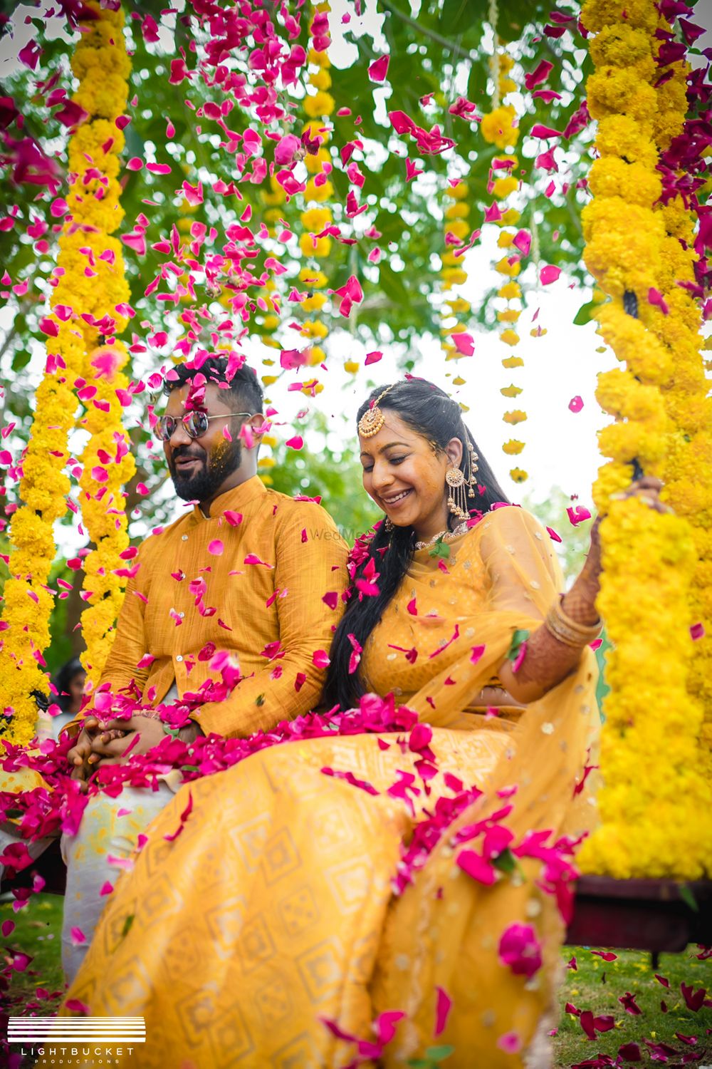 Photo of Haldi bride and groom portrait with petal shower