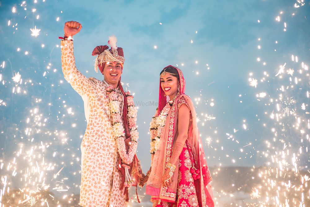 Photo of A bride and groom amidst sparklers