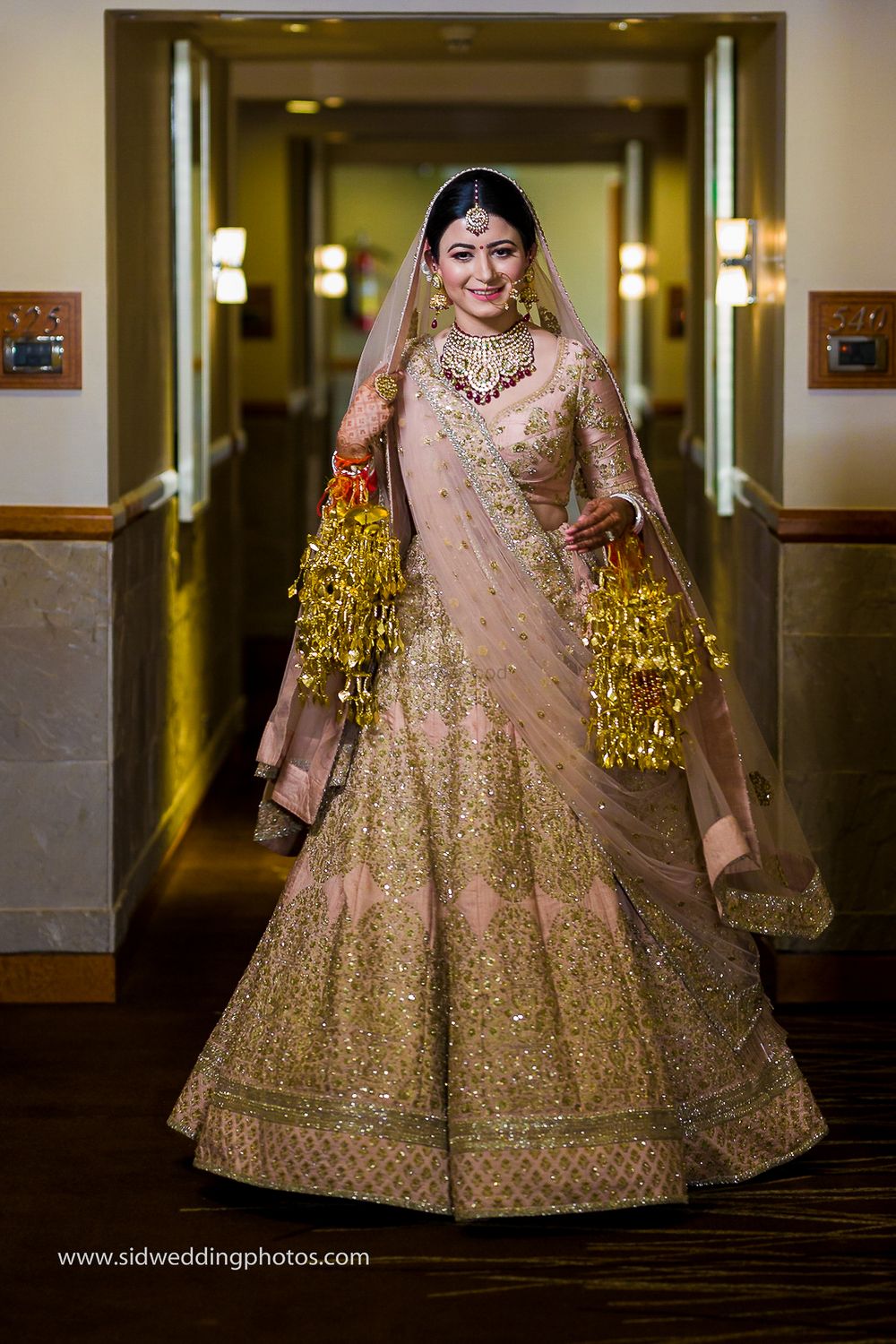 Photo of Bride twirls in pink and gold lehenga