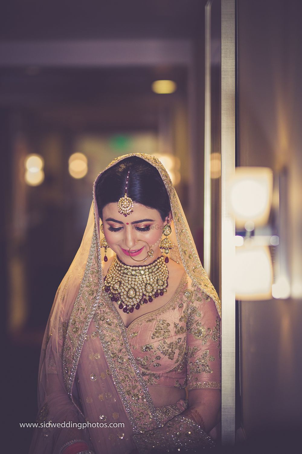 Photo of Bride in light pink lehenga and heavy polki/jadau jewellery