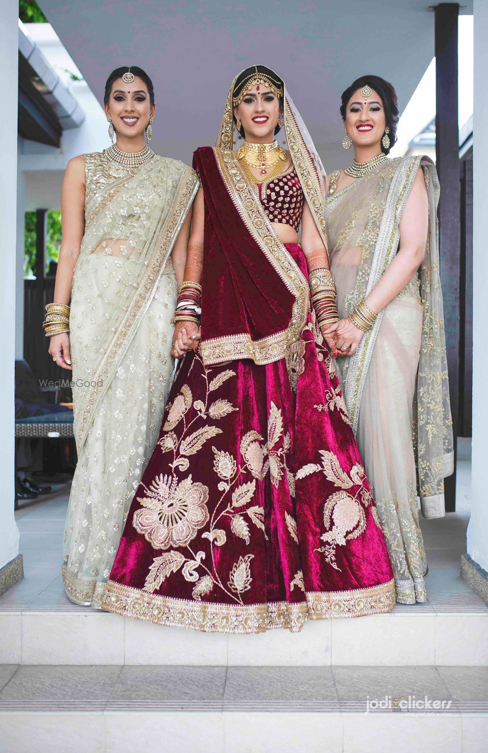 Photo of Bride with sister in velvet lehenga