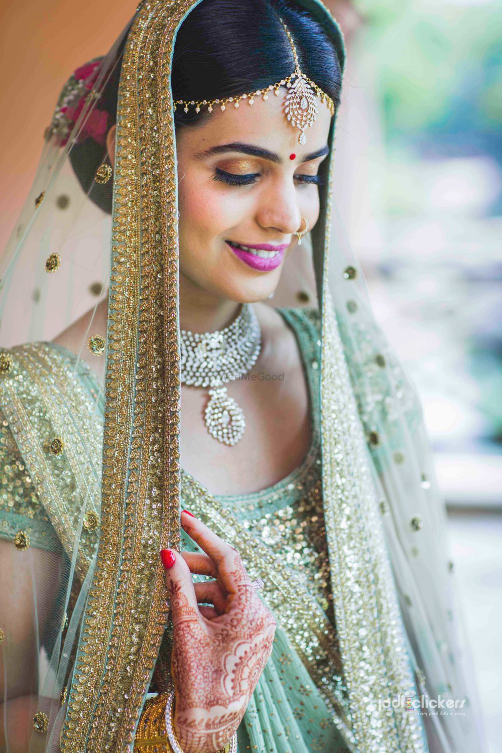 Photo of Bridal portrait with offbeat colour lehenga and red bun