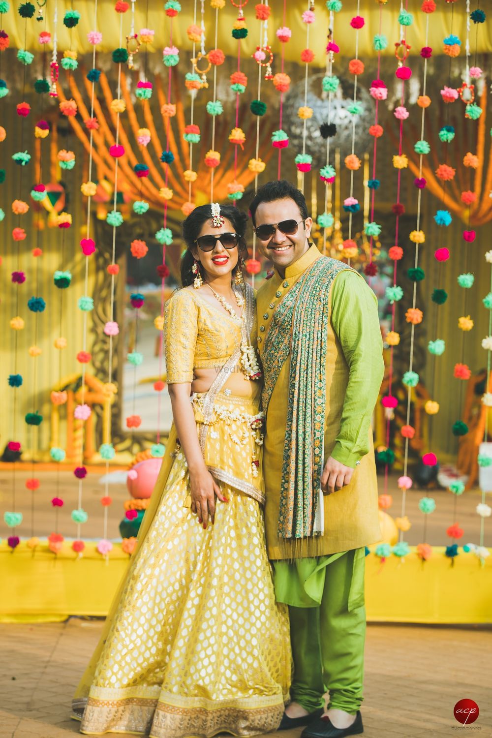 Photo of Mehendi couple portrait with pompom curtain background
